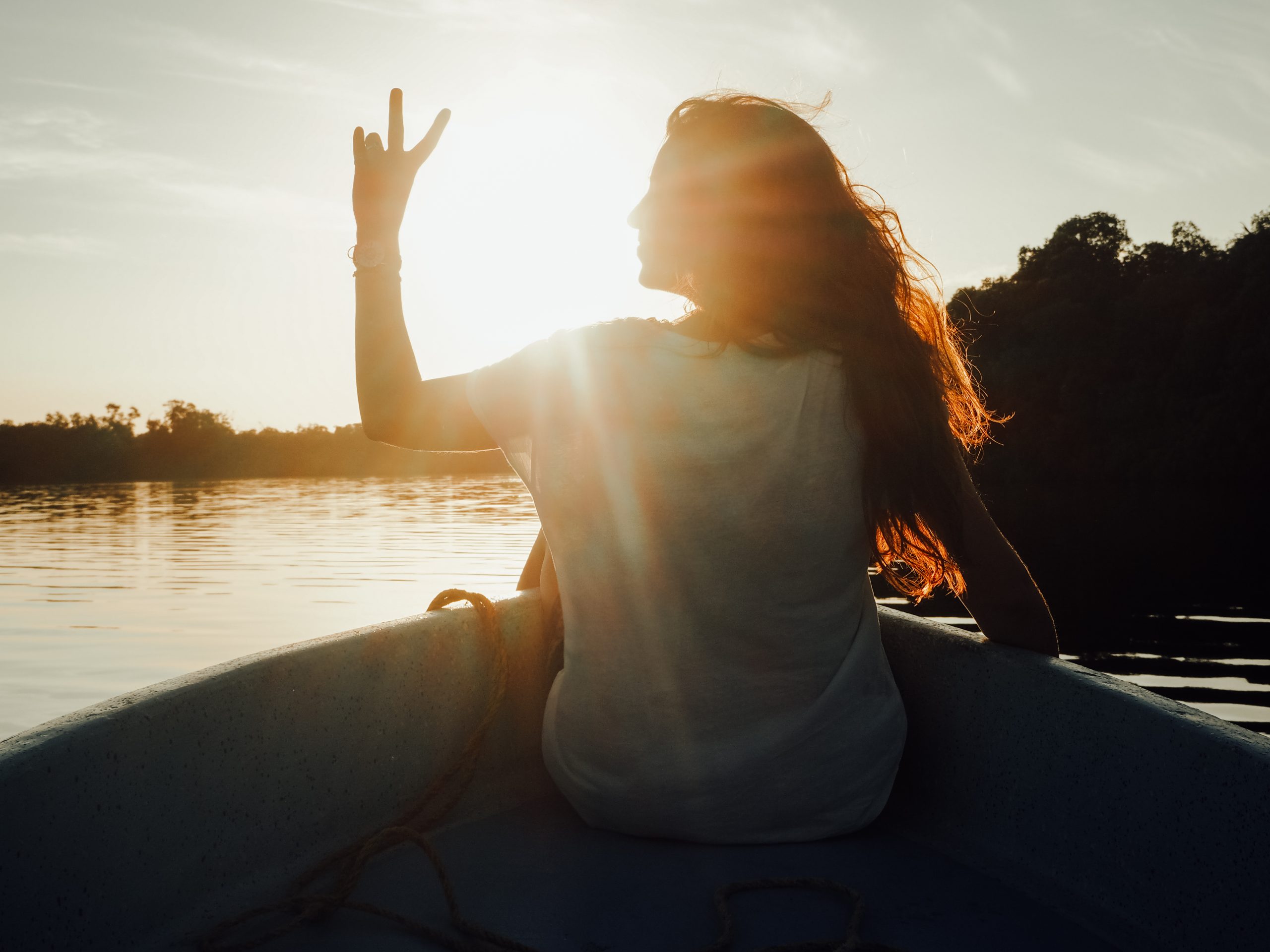 Mädchen auf Boot im Sonnenuntergang