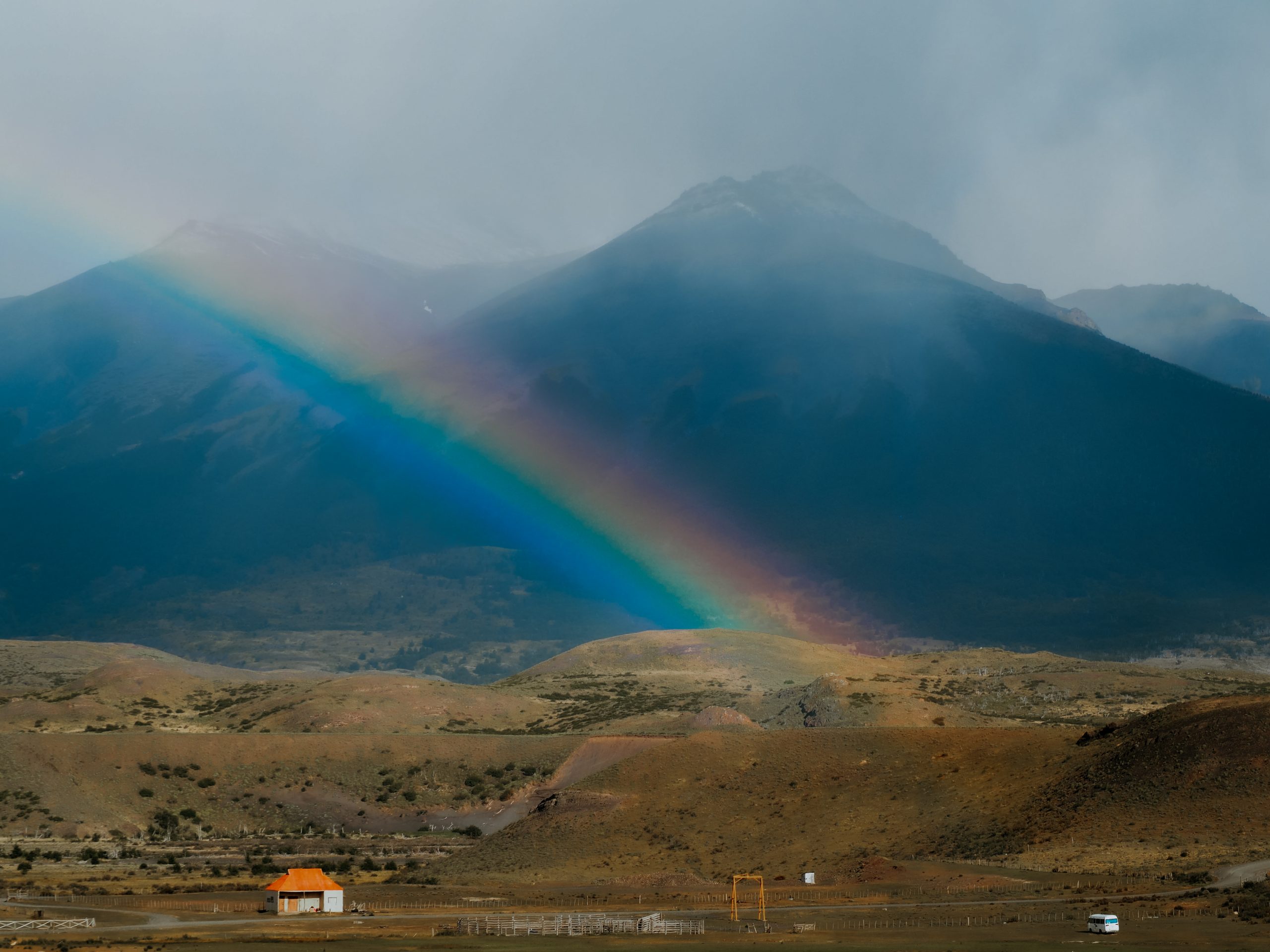 Berge mit Regenbogen und Haus